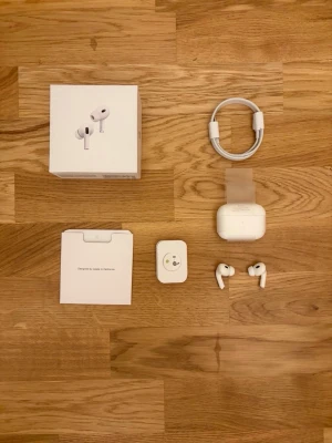  AirPods Pro  - Säljer ett par vita AirPods Pro med laddningsetui, USB-C till Lightning-kabel och originalförpackning. Hörlurarna har en stilren och kompakt design i blank plast och levererar grymt ljud med brusreducering. Perfekta för musik, poddar och samtal.