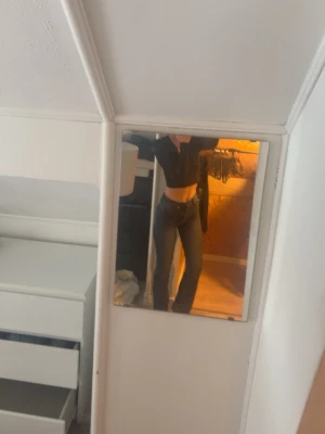 Mörkblå bootcut jeans - Säljer ett par mörkblå bootcut jeans med lätt slitning på låren och klassisk femficksmodell. Jeansen har låg midja och raka ben som blir vidare nedtill. Perfekta för en avslappnad och trendig look.