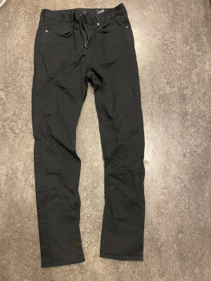 Svarta  jeans slim fit - Säljer ett par svarta jeans m lite stretch,  rak passform och klassisk femficksdesign. Jeansen har bälteshällor och dragkedjegylf. Perfekta till en avslappnad streetwear-look eller att matcha med en hoodie. Aldrig använda endast testade.