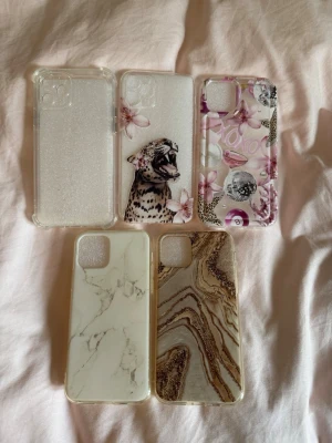 Snygga och trendiga mobilskal med olika mönster - Säljer fem olika mobilskal för iPhone med unika designer: ett genomskinligt med glitter, ett med leopard och blommor, ett rosa med olika trendiga bilder, ett med vit marmor och ett med brunt och gulligt marmormönster. Alla skal är i plast och har modern look som passar dig som vill sticka ut!! SUPER SNYGGA som passar till varje outfit och färg på mobilen❤️Till iPhone 11 Pro.