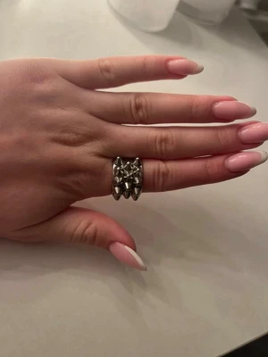 Silvrig ring med nitar och stjärnor - Cool ring i silverfärgad metall med upphöjda nitar och stjärnformade detaljer. Fin ring från Edblad i storlek 16,8mm. PRIS KAN DISKUTERAS!