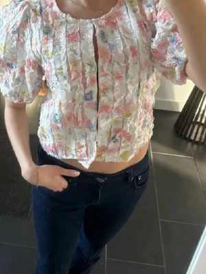 Vit blommig blus  - Säljer min jättesöta och fina topp från Ginatricot i storlek xs !!! Perfekt nu vill våren 🩷🧡💛