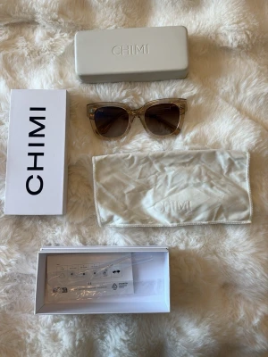 Transparenta solglasögon från CHIMI - Säljer ett par stilrena transparenta solglasögon från CHIMI (08 i färgen eceu). Rektangulär form med bred båge i syntetmaterial. Kommer med originalfodral, orginalfärpakning och putsduk. Perfekta för dig som vill ha en clean och modern look, och endast använda ett fåtal gånger. Inga defekter 💕💕💕