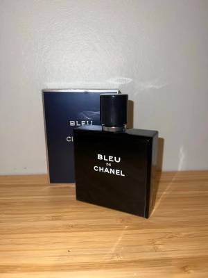 Bleu de Chanel parfym - Bleu de Chanel är en elegant herrparfym i en stilren, mörkblå glasflaska med vit text och svart lock. Flaskan har en fyrkantig form och kommer med originalkartong. En klassisk doft från Chanel som utstrålar lyx och modernitet. Bara använd fåtal gånger och flaskan är nästan helt full.