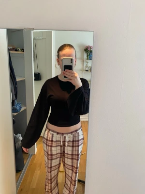 Svart croppad långärmad topp - En svart croppad topp med långa ärmar och rund hals. Enkel och stilren design som passar till det mesta. Tillverkad i mjukt material som känns skönt mot huden. Perfekt att matcha med både jeans och kjol.