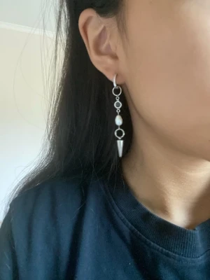 Silverörhängen med sötvattenpärla & konformad avslutning - Priset gäller ett par örhängen  Material: Rostfritt stål & sötvattenpärla  Längd: ca 6,5cm Nickelfria Handgjorda