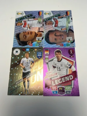 Fotbollskort. Skriv till mig om man vill ha bättre pris - Fyra exklusiva samlarkort med tyska landslagsspelare, inklusive LIMITED EDITION och LEGEND-kort. Kort i metallicfärger som silver, lila och guld med spelare i vita matchtröjor. Perfekt för dig som gillar fotboll och vill ha unika kort i din samling.