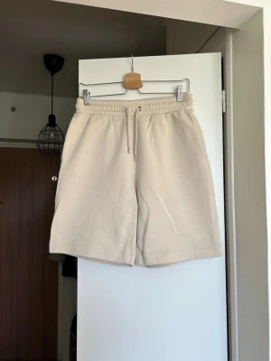 Beige sweatshorts med snörning - Snygga beige shorts med elastisk midja och snörning. Klassisk rak passform från Monki men finns små fläckar (se bild). 