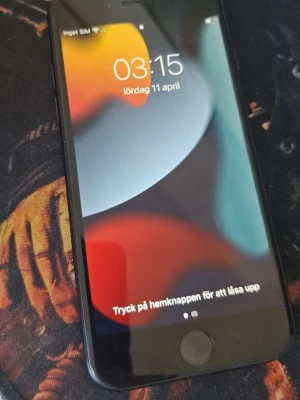 Svart iPhone 7 32gb med hemknapp - Säljer en svart iPhone 7 från Apple. Telefonen har en klassisk rund hemknapp, slimmad design och bakstycke i aluminium. Skärmen är 4,7 tum och baksidan har en enkel kamera med blixt. Perfekt för dig som gillar smidiga mobiler.