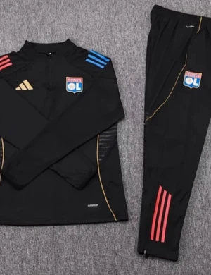 Svart träningsset Lyon Adidas - Säljer ett svart träningsset från Adidas med Olympique Lyonnais klubbmärke. Tröjan har blå och röda detaljer på axlarna, guldiga linjer och dragkedja vid halsen. Byxorna har röda ränder och klubbmärke på benet. Perfekt för fotbollsträning.