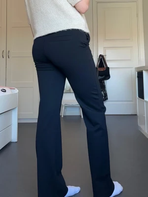 Svarta kostymbyxor - Säljer ett par svarta kostymbyxor med rak passform och pressveck. Byxorna har diskreta fickor bak och är sydda i ett mjukt, följsamt tyg som ger en clean look. Pris går att diskutera!