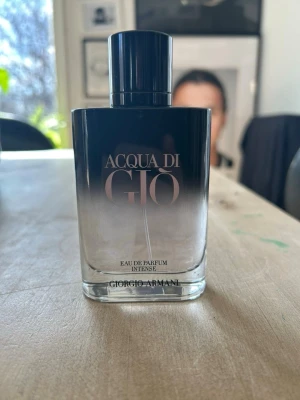 Acqua di Giò Intense Eau de Parfum 100 ml - Helt ny. Acqua di Giò Eau de Parfum från Giorgio Armani i en elegant glasflaska med svart till transparent färgskiftning. Flaskan har en stilren, rundad form och svart lock. En klassisk och fräsch doft som passar perfekt för dig som gillar exklusiva parfymer.