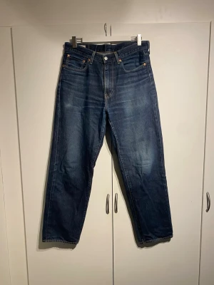 Levis Stay Loose Mörkblå - Säljer ett par klassiska mörkblå jeans från Levi's med raka ben och fem fickor. Modellen heter Stay Loose och är storlek 32 32, true to size. Fint skick, sparsamt använda. Hör av dig för fler bilder