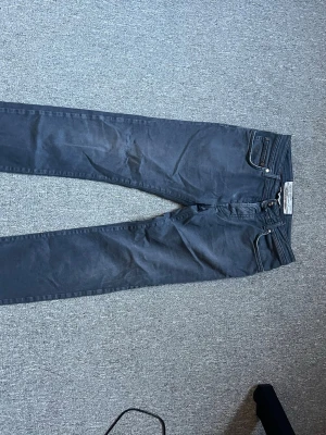 Mörkgrå smala jeans från Jacob cohen, limited edition  - Säljer ett par mörkgrå smala jeans från Jacob cohen Jeans med klassisk femficksmodell och silverfärgade nitar. Jeansen har en rak passform och är tillverkade i mjukt denimtyg. Perfekta för dig som gillar en clean och stilren look.