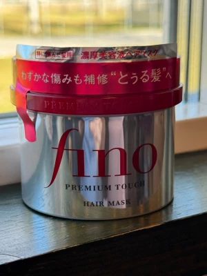 Fino Premium Touch hårmask - Fino Premium Touch hårmask i en silverfärgad burk med röd plastlock. Innehåller 230g och är en intensiv hårinpackning som återfuktar och reparerar håret. Perfekt för dig som vill ha mjukt och glansigt hår. Japansk produkt med lyxig känsla.