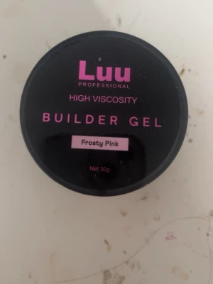 Luu Builder Gel Frosty Pink 30g - Bygggele från Luu Professional i färgen Frosty Pink. Gelen har hög viskositet och kommer i en svart burk med rosa text. Perfekt för att bygga och forma naglar med en snygg, mjuk rosa ton. Innehåller 30g gelé som ger ett proffsigt resultat. Endast testad på en nagel