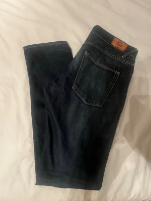Raw denim jeans från Acne  - Säljer ett par raw denim jeans från Acne Studios med raka ben. Jeansen har snygga kontrastsömmar och en läderpatch med logga bak i midjan. Perfekta till vardagslooken och tillverkade i slitstarkt denimtyg. Modell heter Mod Raw. 30/34.