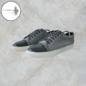 Grå sneakers med lackad tå - Lanvin skor i grå färg i storlek 8 (motsvarar ca 42-43, lanvins är något stora i storleken). Färgen är perfekt inför sommaren! Skick 8,5/10 lätt sprickbildning i lacket på cap toe på grund av creases, inget som är särskilt märkbart med blotta ögat, speciellt inte på håll eller vid användning. I övrigt väldigt fint skick. Endast skorna ingår. Hör av dig för mått!                            ~ Nypris cirka 4 000–6 000 kr | Vårt pris 2 199 kr. Alla följare får rabatt, så följ!