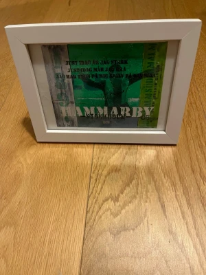 Hammarby tavla - Säljer en tavla med Hammarby-motiv i grönt och vitt, inramad i en stilren vit träram. Texten på motivet innehåller Hammarby och citat från en känd sång. Perfekt för dig som vill visa ditt stöd för laget.