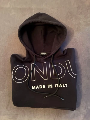 Dondup Hoodie - Säljer nu denna Dondup Hoodie herr. Den är knappt använd, så är i bra skick. Köpt ny för 1999kr. Den passar dig som har S men kan även passa dig som har M då den är rätt stor i storlek. Hör av dig vid frågor!