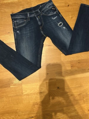 Mörkblå slitna skinny jeans Only - Mörkblå skinny jeans från Only med slitningar och distressed detaljer på låren och knäna. Klassisk femficksmodell med låg midja och smal passform. Jeansen har en snygg tvätt och är tillverkade i stretchigt denimtyg för extra komfort.