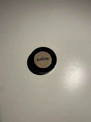 Isadora ögonskugga champagne - Snygg singelögonskugga från Isadora i en skimrande champagnefärg. Kommer i en rund svart plastförpackning med genomskinligt lock och magnetisk stöngfunktion. Perfekt för att skapa en glansig look och highlighta ögonlocken.
