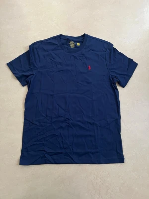 Ralph lauren T-shirt mörkblå storlek medium  - Ny Ralph Lauren t-shirt med klassisk passform. Perfekt basplagg till sommaren.  Oanvänd Väldigt populär modell Enkel att matcha  Skickas snabbt 📦 Rabatt vid köp av flera.