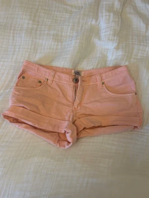 Korall jeansshorts - Ljusrosa / corall trendiga jeansshorts från HM. Lågmidjade 🙂Super trendig färg till sommaren!!💕💕💕💕💕🧡🧡🧡🧡