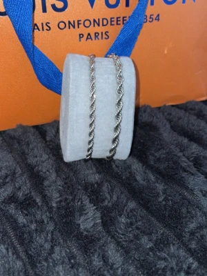 ( 2 för 160kr) Silverfärgat tvinnat armband - ( 2 för 160kr).                                            Säljer ett stilrent armband i silverfärg med tvinnad kedja. Armbandet har en klassisk design som passar till många olika stilar. Materialet ser ut att vara metall och kedjan har en snygg, vriden form.