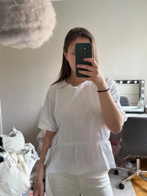 Vit blus med knyt i midjan - Säljer en söt vit blus med korta ärmar och knyt i midjan. 