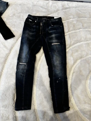 Blåa Jeans Med Slitningar - Snygga mörkblå skinny jeans med slitningar och lätt tvättade detaljer. De är från Black island och de kostar endast 300kr. Helt nya. Hör av dej vid intresse! 