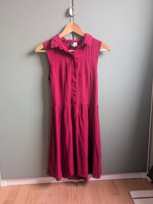 Ärmlös skjortklänning - Snygg mörkrosa/plommonfärgad ärmlös klänning i viskos. Storlek 38 på lappen men liten i storlek så skulle säga 36. Otrolig färg som fångas bäst på sista bilden. 