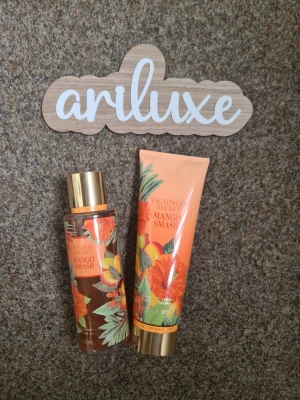 Victoria's Secret Mango Smash set - Fräsch parfym och lotion från Victoria's Secret i doften Mango Smash. Flaskan är transparent med tropiskt blommönster i orange, grönt och guld, och har en guldfärgad kork. Perfekt för dig som gillar fruktiga och exotiska dofter. Helt nytt och oanvänt