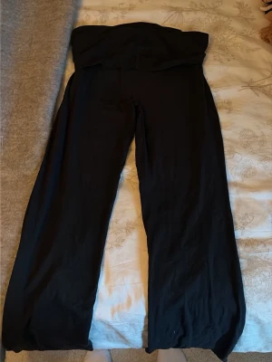 Svarta vida leggings med hög midja - Säljer ett par svarta leggings med hög midja och vida ben. De är mjuka och stretchiga, perfekta för en avslappnad och trendig look. Passar dig som gillar bekväma och stilrena plagg.