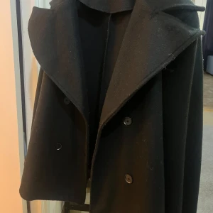 Svart kappa - Jättefin kappa som passar till alla tillfällen, den är väldigt skön att ha på sig och går verkligen att styla till allt! Storleken är S eller 34-36. Endast använd 4-5 gånger.