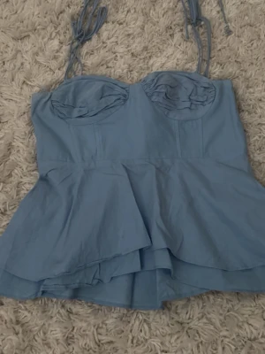 Blå korsettopp från Zara - Supersnygg blå korsettopp från Zara med volang nertill och knytbara axelband!!!💕