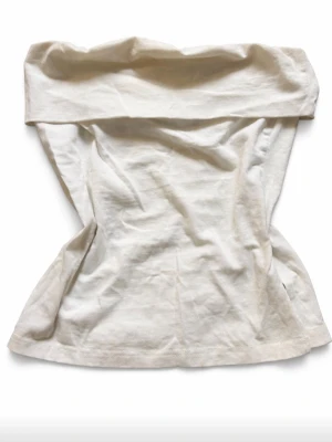 Vit axelbandslös tubtopp - Snygg vit tubtopp med bred kant upptill. Toppen är axelbandslös och har en enkel, stilren design som passar perfekt till sommaren. Stolek XS. 