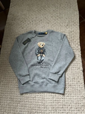  Polo Bear Ralph Lauren sweatshirt  - Säljer denna Gråa sweatshirt från Ralph Lauren. Skicket är helt nytt, tröjan är endast testad. Priset går att diskutera. Skriv vid frågor eller funderingar 🤩