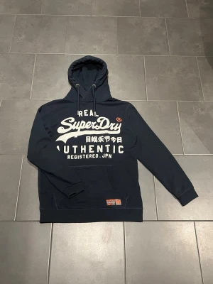 Superdry hoodie  - Säljer nu denna superdry hoodie som är i bra skick. Jag har inte använt den så mycket då storleken blev fel så den är typ ny. Hör av er vid frågor! 