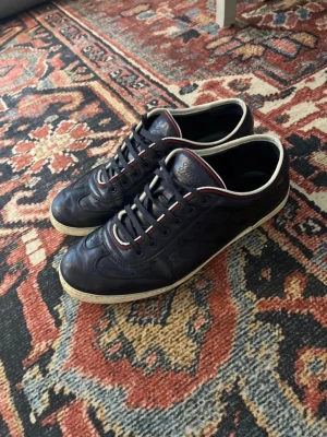 Mörkblå sneakers från Gucci - Riktigt snygga Gucci skor i en unik model.                      Skorna är i storlek 43 och har riktigt bra skick.        Om du har någon fundering är de bara att fråga!