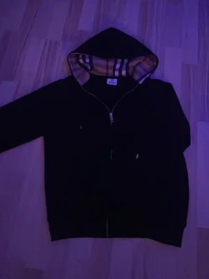 Burberry hoodie - Svart hoodie från Burberry. Den är varm o perfekt nu till våren och på sommaren. (OBS ENA FICKAN ÄR LITE SÖNDER) Om du vill prata Pris kom pm