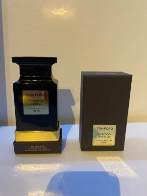 Tom Ford Tobacco Vanille 100ml parfym - Tom Ford Tobacco Vanille Eau de Parfum i en lyxig svart flaska med gulddetaljer. Flaskan rymmer 100 ml och kommer med originalkartong. En ikonisk doft med inslag av tobak och vanilj, perfekt för dig som gillar exklusiva och varma parfymer.