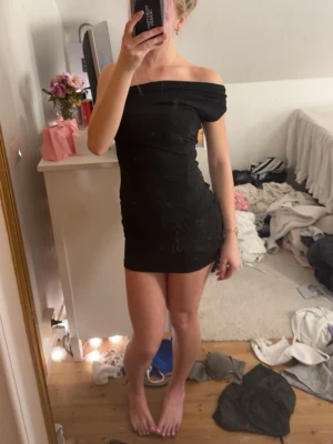 Svart offshoulder klänning BikBok - Snygg svart kort offshoulder klänning från BikBok. Tight passform som framhäver figuren och passar perfekt till dig som gillar en stilren look. Klänningen är enkel och utan mönster, vilket gör den lätt att styla med accessoarer.