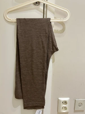  Ny Bruna leggings i mjukt material , merinoull  - Säljer ett par bruna leggings i stretchigt och mjukt tyg. De har en enkel, slim fit design utan synliga detaljer eller fickor. Perfekta att matcha med oversized tröjor eller hoodies för en chill look.