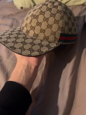 Beige gucci keps canvas - Äkta Gucci keps, gamla modellen, köpt 2020, finns Gucci chip i den men ofungerande då den är gammal, inga andra tillbehör kvar, har digital kvitto från säljaren som jag köpte ifrån här på Plick.