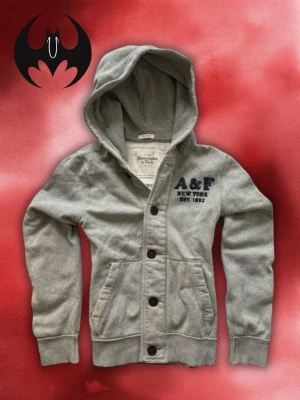 Grå Abercrombie & Fitch Kofta  - Grå A&F Kofta | mycket bra skick, snöre saknas | Size M/L| Längd: 68cm Axelbredd: 46cm Armlängd: 68cm | Modell, 178cm 60kg | Lägg endast bud med avsikt att köpa, inga fördröjning!