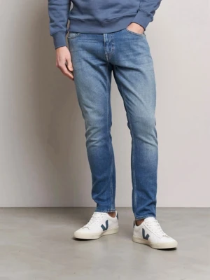 Ljusblå raka jeans från Tiger Of Sweden - Säljer ett par ljusblå jeans från Tiger Of Sweden med rak passform och klassisk femficksdesign. Jeansen har en snygg tvättad look med subtila slitningar och är tillverkade i bomull. Perfekta för en avslappnad och stilren outfit.