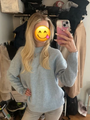 Ljusblå stickad tröja - Mysig ljusblå stickad tröja med rund hals och långa ärmar. Tröjan har ribbstickade muddar vid ärmslut och nederkant. Perfekt för kyliga dagar och enkel att matcha med jeans eller kjol.