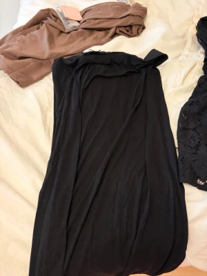 Svart långkjol från 157 - En svart långkjol från 157 i enkel och stilren design. Kjolen har en rak passform och är gjord i ett mjukt material som känns bekvämt. Perfekt att matcha med en crop top eller hoodie för en chill look.