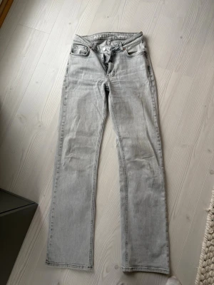 Ljusgrå raka jeans från Bik Bok - Säljer ett par ljusgrå jeans med rak passform och klassisk femficksdesign. Jeansen har normal midja och stängs med dragkedja och knapp. Perfekta för en avslappnad och trendig look. Jag är cirka 172 cm men kan också sys upp. 